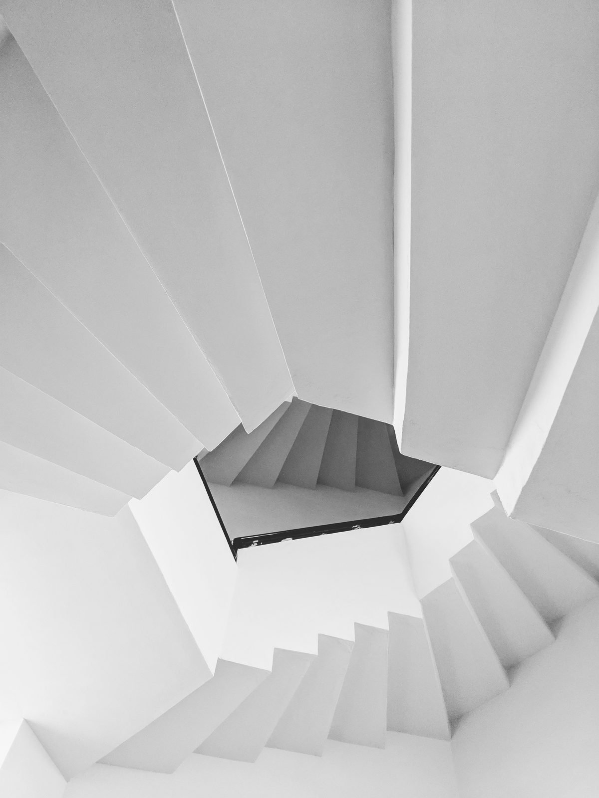 A white spiral staircase seen from above.